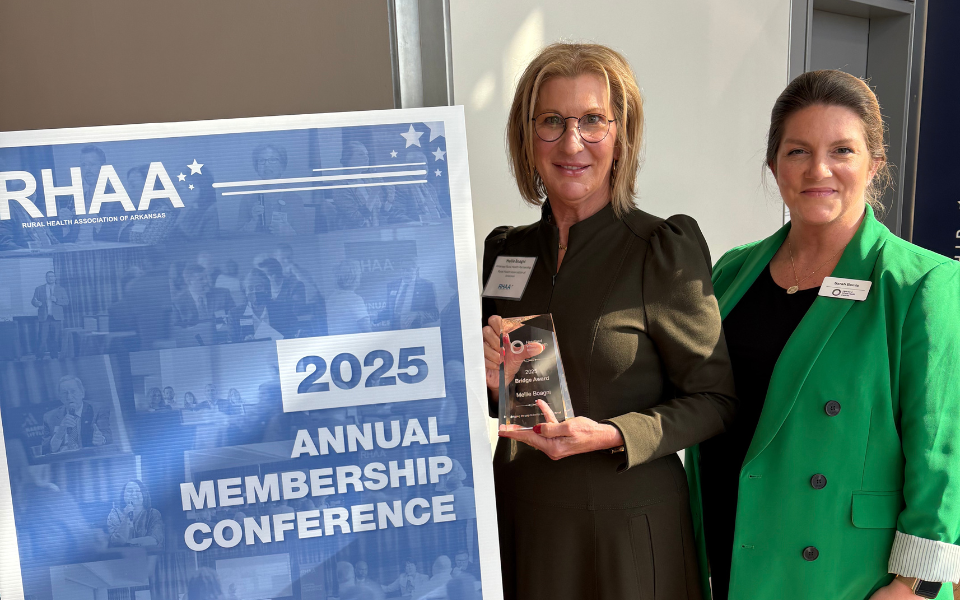 Mellie Boagni and Dr. Sarah Bemis stand together while Mellie holds an award.