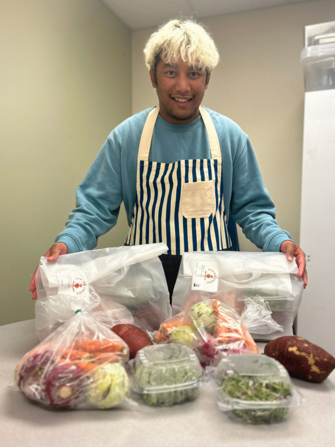 Person standing above a table with produce bags and fruit.