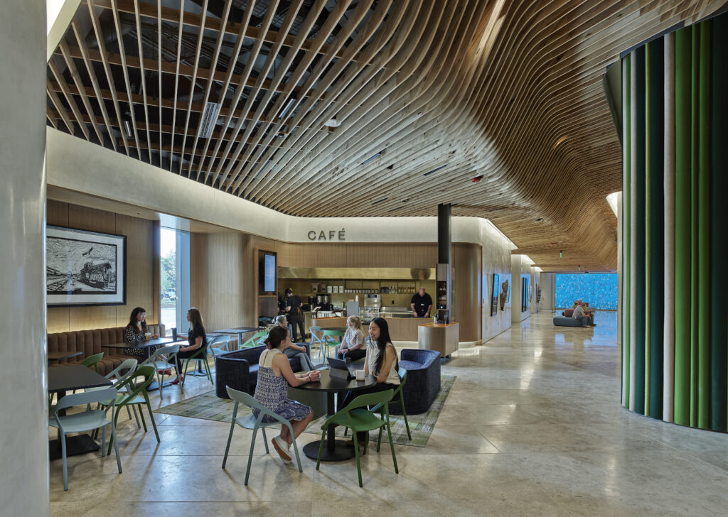 Zoomed out image of the cafe on the first floor. A few people sit at tables interacting with each other.